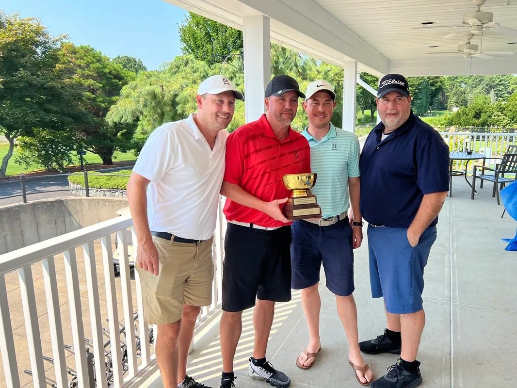 Four Men Holding Trophy